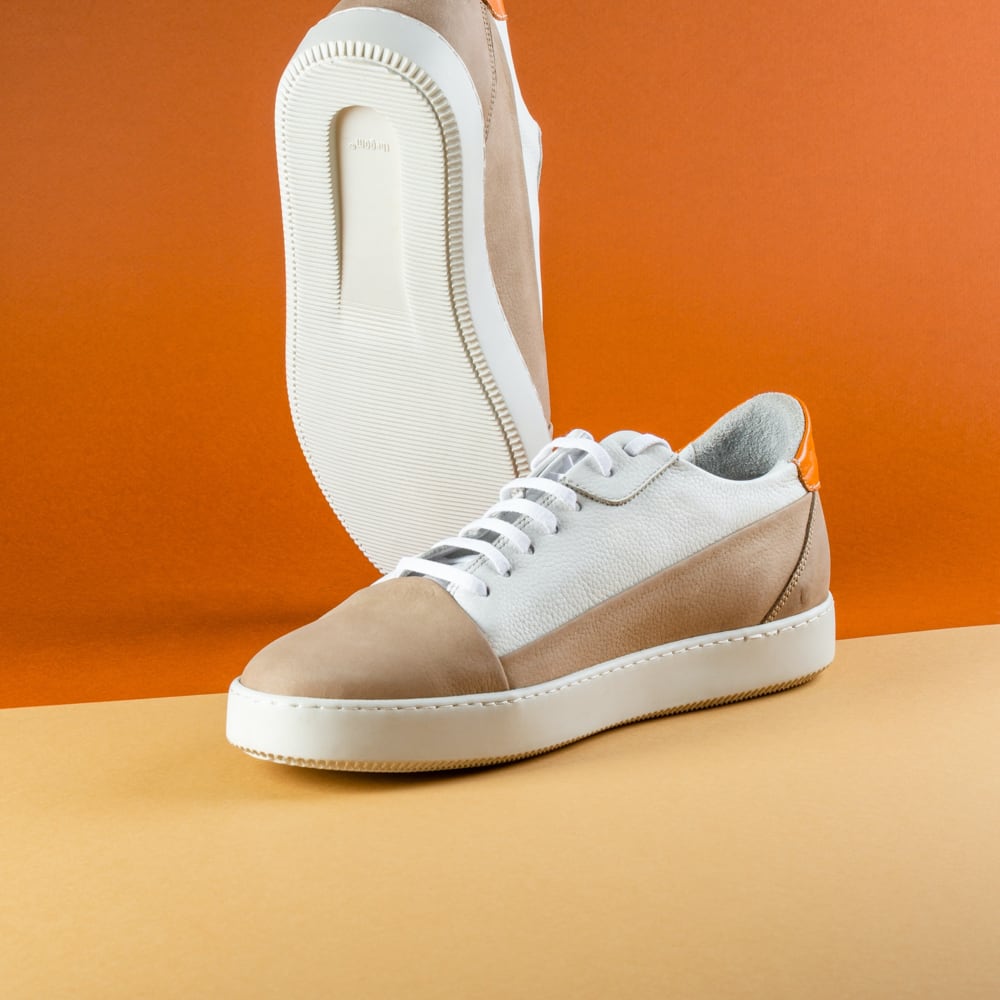 Image of brown and white shoes in orange background