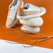 Image of brown and white shoes in orange background