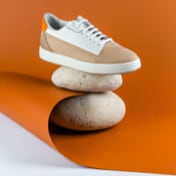 Image of brown and white shoes in orange background